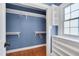 Walk-in closet featuring built-in shelves and hanging rods, with a window for natural light at 1007 W Markham Ave, Durham, NC 27701