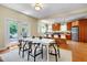 Open-concept dining area with white table, black chairs, hardwood flooring, and view of the kitchen at 1007 W Markham Ave, Durham, NC 27701