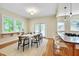 Bright dining room featuring hardwood floors, a modern table set, and direct access to the kitchen at 1007 W Markham Ave, Durham, NC 27701