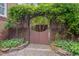 An arched garden gate is covered in vines leading into a lush backyard at 1007 W Markham Ave, Durham, NC 27701