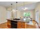 Island kitchen with granite countertops, stainless steel appliances, and open dining area with pendant lighting and view at 1007 W Markham Ave, Durham, NC 27701