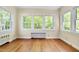 Bright living room with hardwood floors and many windows that provide natural light and views of the property's landscape at 1007 W Markham Ave, Durham, NC 27701