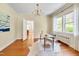 Bright home office with hardwood floors, natural light from the large windows, and a stylish desk and chair at 1007 W Markham Ave, Durham, NC 27701