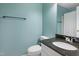 Bathroom with a dark granite countertop, white sink, toilet, and a large mirror at 109 Crane Meadow Pl, Chapel Hill, NC 27514