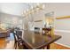 Dining area with a wooden table, modern lighting fixture, and access to other rooms at 109 Crane Meadow Pl, Chapel Hill, NC 27514