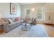 Spacious living room with an L-shaped gray sofa, geometric art, and ample sunlight at 109 Crane Meadow Pl, Chapel Hill, NC 27514