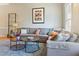 A cozy living room featuring a plush gray sectional sofa, modern decor, and a stylish blue rug at 109 Crane Meadow Pl, Chapel Hill, NC 27514
