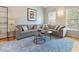 Bright living room with a gray couch, modern art, and a large window at 109 Crane Meadow Pl, Chapel Hill, NC 27514