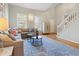 Open living space with a gray sofa, oak hardwood floors, and natural light at 109 Crane Meadow Pl, Chapel Hill, NC 27514