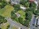 Expansive aerial view of the property surrounded by lush trees near street and parking at 118 N 7Th St, Smithfield, NC 27577
