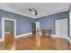 Spacious blue bedroom with wood floors, ceiling fan, and a vintage dresser at 118 N 7Th St, Smithfield, NC 27577