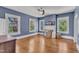Blue bedroom featuring three windows, ceiling fan, and hardwood floors at 118 N 7Th St, Smithfield, NC 27577