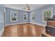 Light blue bedroom featuring three windows and beautiful hardwood floors at 118 N 7Th St, Smithfield, NC 27577
