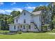 This is a large, multi-story home featuring white siding, a metal staircase, and a covered side porch for outdoor enjoyment at 118 N 7Th St, Smithfield, NC 27577