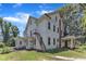 This is a large, multi-story home featuring white siding, a metal staircase, and a covered side porch for outdoor enjoyment at 118 N 7Th St, Smithfield, NC 27577