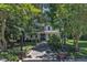 View of the home's exterior framed by mature trees, with a walkway leading to the inviting front porch at 118 N 7Th St, Smithfield, NC 27577