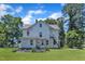 Back of the property featuring an expansive lawn and white siding, complemented by mature trees at 118 N 7Th St, Smithfield, NC 27577