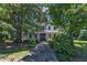 Exterior view of the home showing mature trees, sidewalk and landscaping at 118 N 7Th St, Smithfield, NC 27577