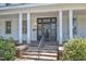 Charming front entrance with a classic black door, white columns, brick steps, and landscaped greenery for curb appeal at 118 N 7Th St, Smithfield, NC 27577