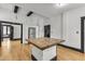 Open kitchen design with a kitchen island, white cabinets, stainless steel appliances, and hardwood floors at 118 N 7Th St, Smithfield, NC 27577