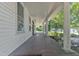A long, covered porch with white columns and a wooden floor, offering a welcoming entrance and outdoor seating area at 118 N 7Th St, Smithfield, NC 27577