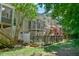 View of the home exterior and backyard with lush greenery, featuring a fenced garden and raised garden beds at 119 Jones Creek Place Pl # 119, Chapel Hill, NC 27516