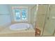 Luxurious bathroom featuring a soaking tub, walk-in shower, and tiled floors at 119 Jones Creek Place Pl # 119, Chapel Hill, NC 27516