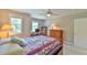 Cozy bedroom features two windows, a ceiling fan, and a colorful quilt on the bed at 119 Jones Creek Place Pl # 119, Chapel Hill, NC 27516