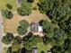 An overhead aerial view of the property, featuring a home with a deck surrounded by mature trees and a lush green lawn at 119 Percheron Dr, Zebulon, NC 27597