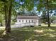 View of the home's back exterior with a white deck and wheelchair ramp nestled in a lush, green backyard at 119 Percheron Dr, Zebulon, NC 27597