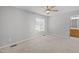 This carpeted bedroom features a ceiling fan and a window view to the attached bathroom at 119 Percheron Dr, Zebulon, NC 27597
