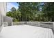 A large, white wooden deck surrounded by lush trees offers plenty of space for outdoor living at 119 Percheron Dr, Zebulon, NC 27597