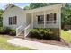 This home features a cozy front porch with white railings and attractive landscaping at 119 Percheron Dr, Zebulon, NC 27597