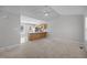 Open-concept living space featuring neutral carpet, ceiling fan, and an open kitchen at 119 Percheron Dr, Zebulon, NC 27597