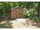 Backyard shot of the property's storage shed with dual doors, ramp access, and rustic wood construction at 119 Percheron Dr, Zebulon, NC 27597