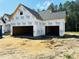 View of a new construction home showcasing the two-car garage and the Tyvek HomeWrap at 128 Seahawk Way, Zebulon, NC 27597