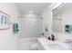 Modern bathroom with tub and shower combo, glass doors, marble tile, and vanity with quartz countertops at 1309 Hudson Ave # D6, Durham, NC 27705