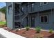 View of the apartment building showcasing exterior stairs, muted blue siding, and tasteful landscaping at 1309 Hudson Ave # D6, Durham, NC 27705