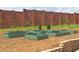 Backyard garden featuring raised garden beds, with manicured lawn and a tall brick wall backdrop at 1309 Hudson Ave # D6, Durham, NC 27705