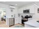 Bright kitchen with white cabinets, stainless steel appliances, and view to bedroom at 1309 Hudson Ave # D6, Durham, NC 27705