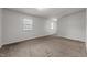 Bright bedroom featuring neutral carpet, ceiling fan, and natural light from two windows at 1402 Tarleton Ave, Burlington, NC 27215