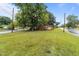 Charming brick home with a spacious front lawn and mature trees lining the street at 1402 Tarleton Ave, Burlington, NC 27215
