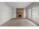 Cozy living room with brick fireplace and access to outdoor space through sliding glass doors at 1402 Tarleton Ave, Burlington, NC 27215
