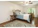 Cozy bedroom with a wrought iron bed frame, hardwood floors, and natural light at 1487 Kentucky Ave, Sanford, NC 27332