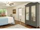 Bright bedroom featuring antique armoire, comfortable bed, and access to exterior at 1487 Kentucky Ave, Sanford, NC 27332
