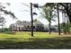 Exterior of the brick and white clubhouse featuring a long front porch and well-manicured lawn at 1487 Kentucky Ave, Sanford, NC 27332
