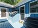 Deck area showing blue exterior wood with white trim, windows, and access door to home at 1487 Kentucky Ave, Sanford, NC 27332