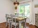 Charming dining area with wood table, decorative chairs, and a sunlit window at 1487 Kentucky Ave, Sanford, NC 27332