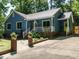 Cozy home boasting vibrant blue siding, pristine landscaping, a metal roof, and inviting white porch at 1487 Kentucky Ave, Sanford, NC 27332