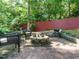 Backyard fire pit with stone border and seating, plus a charcoal grill, for outdoor entertainment at 1487 Kentucky Ave, Sanford, NC 27332